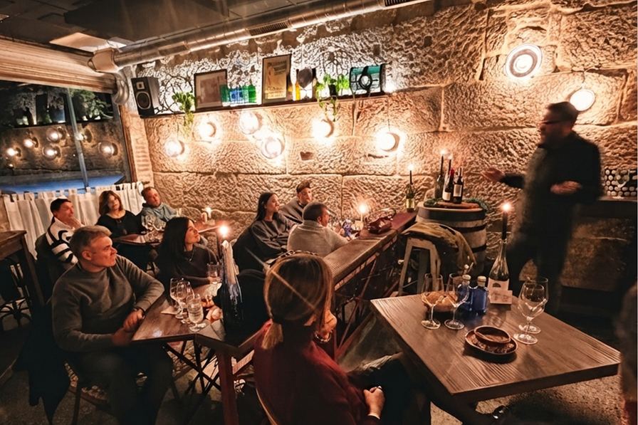 Formación de sala junto a un grupo sentado en un ambiente de bodega íntimo